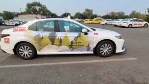Featured image showing a taxi cab wrapped with local student artwork