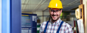 Featured image showing a happy male employee working at an advanced manufacturing job